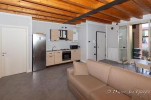 sala de estar con sofá y cocina en Dimora San Giorgio - Vicino Leolandia e Bergamo, en Bonate Sotto