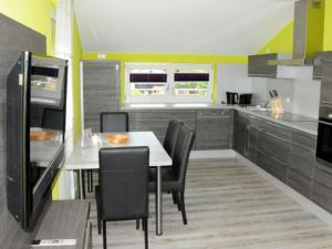 Una cocina con una mesa y sillas en una cocina. en Caseti 5_ Ferienwohnungen _ Rothen, en Oberdachstetten