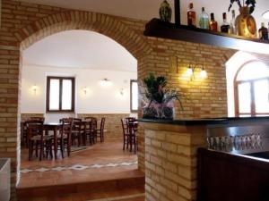un restaurante con una pared de ladrillo, mesas y sillas en Agriturismo Raggioverde, en Recanati