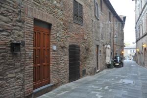 een steeg met een bakstenen gebouw met een houten deur bij Atelier di Denise in Panicale