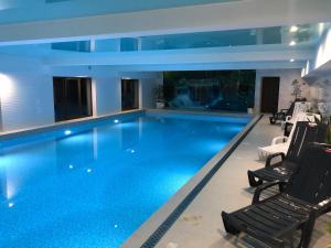 a swimming pool in a building with chairs around it at КРЕМІНЬ in Dragobrat