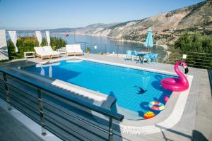 een zwembad met een roze flamingo op een balkon bij Villa Margarita in Zóla