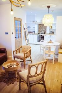 salon z krzesłami i stołem oraz kuchnia w obiekcie At The River w mieście Dundee
