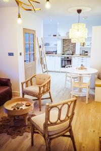 a living room with chairs and a table and a kitchen at At The River in Dundee