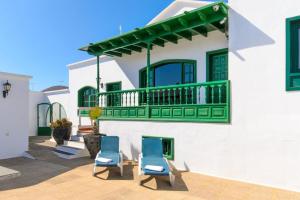 un patio con 2 sillas azules frente a un edificio en HOTEL-FINCA Rural José Manuel 28pax, en San Bartolomé