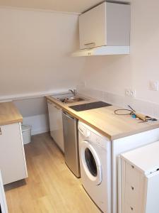 a kitchen with a washing machine and a sink at Le Fleury - Studio calme proche de Rouen in Déville-lès-Rouen