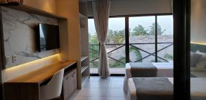 a hotel room with two beds and a large window at Belíssimo apartamento em Barra Grande Cobertura Villas BobZ 101 m2 com Vista Para o Mar, Barrinha, Barra Grande-PI in Barrinha
