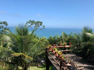 einen Balkon mit Palmen und dem Meer im Hintergrund in der Unterkunft Espaço Indio Tupi in Trindade
