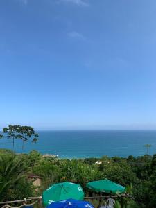 zwei blaue Regenschirme am Meer in der Unterkunft Espaço Indio Tupi in Trindade