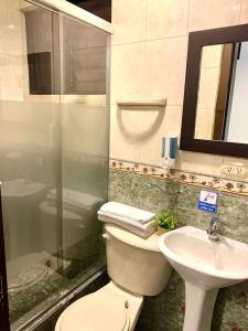 een badkamer met een toilet en een wastafel bij HOSTAL EL CAJAS in Cuenca