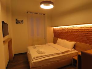 2BR loft apartment near Liberty square في تبليسي: غرفة نوم صغيرة مع سرير بجدار من الطوب