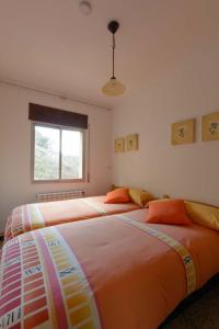 Duas camas estão alinhadas num quarto em Apartaments La Pertusa 2o em Corçà