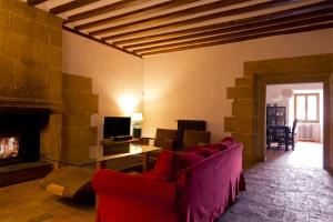 a living room with a red couch and a fireplace at Casa rural Casa fuerte San Gregorio II in Almarza