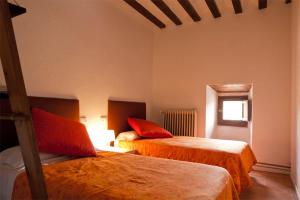 AlmarzaにあるCasa rural Casa fuerte San Gregorio IIのベッドルーム1室(ベッド2台、窓付)