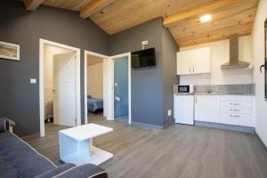 salon z kanapą i kuchnią w obiekcie TEIRABOA BASE CAMP w mieście Arzúa