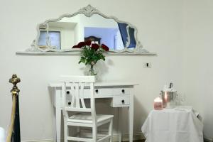 een wit bureau met een spiegel en een witte stoel bij Hotel Al Castello in Pomezia