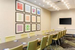 a conference room with tables and chairs and a flat screen tv at Holiday Inn Express & Suites Chicago O'Hare Airport by IHG in Des Plaines +43 photos