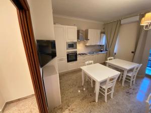 a kitchen with white cabinets and a table and chairs at B&B San Michele Foggia in Foggia