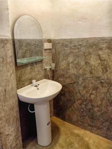 y baño con lavabo blanco y espejo. en Kodi Beach Home, en Galle