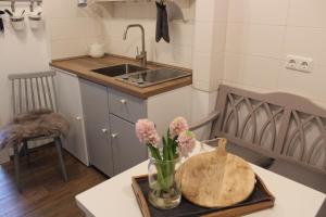 a kitchen with a vase of flowers on a table at KLEINE LANDLIEBE in Hohwacht