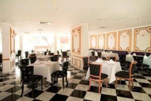 een restaurant met tafels en stoelen en een geruite vloer bij NM Lima Hotel in Lima
