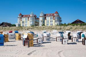 ein Haufen Stühle am Strand mit Gebäuden im Hintergrund in der Unterkunft Dünenresidenz A05 in Bansin
