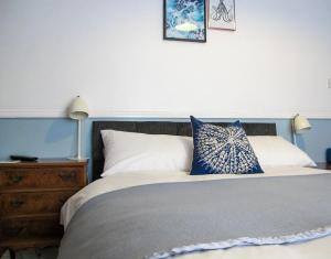 a bedroom with a large bed with a blue headboard at Stone's Throw Guest House in Weymouth