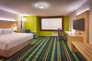 a hotel room with a bed and a flat screen tv at Holiday Inn Express & Suites Phoenix West - Buckeye, an IHG Hotel in Buckeye