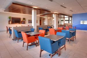 a dining room with tables and blue chairs at Holiday Inn Express & Suites Phoenix West - Buckeye by IHG in Buckeye