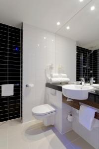a bathroom with a sink and a toilet and a mirror at Holiday Inn Express Amsterdam Arena Towers, an IHG Hotel in Amsterdam