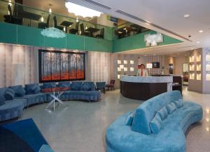 um grande átrio com sofás azuis e um bar em Holiday Inn Express & Suites Queretaro, an IHG Hotel em Querétaro