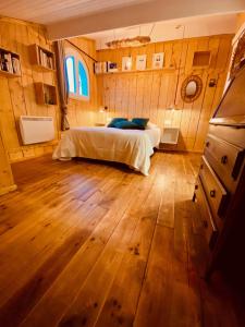 Schlafzimmer mit einem Bett und Holzboden in der Unterkunft Hôtel Le Caillebotis in Cap-Ferret