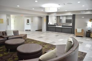 a lobby with couches and chairs and a kitchen at Candlewood Suites Independence, an IHG Hotel in Selsa