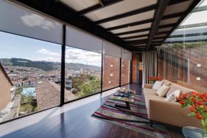 a living room with a couch and large windows at Hotel Casa Gardenia in Quito