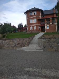 a large brick building with stairs in front of it at Milana Guesthouse in Slavske