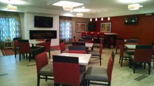 a restaurant with tables and chairs and a fireplace at Holiday Inn Express Cloverdale - Greencastle, an IHG Hotel in Cloverdale