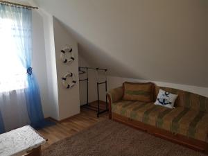 ein Wohnzimmer mit einem Sofa und einem Fenster in der Unterkunft DOM NA MAZURACH in Przerwanki