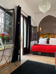 ein Schlafzimmer mit einem großen Bett mit einer roten Tagesdecke in der Unterkunft Riad Dar Massai in Marrakesch