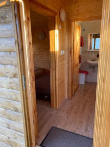 a hallway of a log cabin with a sink and a bathroom at Chata pri jazere - 6km od Slovakia Ringu in Horná Potôň