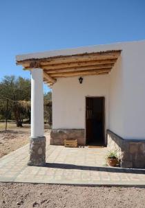 a small white building with a large doorway at El Zorro Gris in Tinogasta