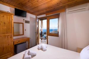 a bedroom with a view of the ocean at Archodissa Pansion in Alyki
