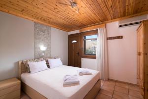 a bedroom with a bed with a wooden ceiling at Archodissa Pansion in Alyki