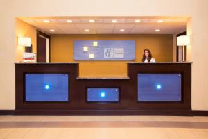 a woman standing behind a counter in a hotel lobby at Holiday Inn Express Lexington Southwest Nicholasville, an IHG Hotel in Nicholasville