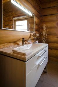 un baño con lavabo y espejo en Luxus-Ferienhaus Blockhaus Chalet Nr 3 Toplage am Feldberg mit Sauna, Outdoor-Hottub, Kamin auf 1300m üM, en Feldberg