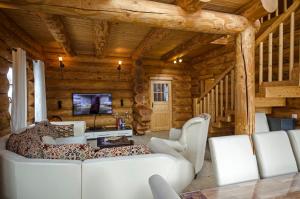 una sala de estar con muebles blancos en una cabaña de madera en Luxus-Ferienhaus Blockhaus Chalet Nr 3 Toplage am Feldberg mit Sauna, Outdoor-Hottub, Kamin auf 1300m üM, en Feldberg