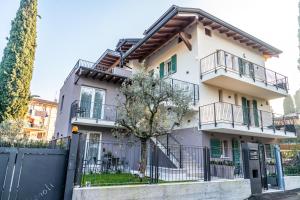 a white house with balconies and a fence at IL NIDO DEGLI USIGNOLI in Peschiera del Garda