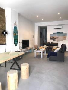 a living room with a couch and a surfboard at Cabanyal Beach House in Valencia