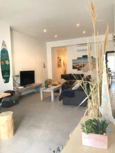 un salon avec une planche de surf sur le mur dans l'établissement Cabanyal Beach House, à Valence