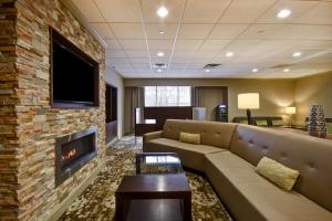 a living room with a couch and a fireplace at Holiday Inn Cincinnati-Riverfront, an IHG Hotel in Covington