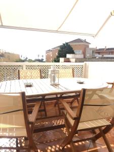 a wooden table and chairs on a patio at Ático, Islantilla in Islantilla +21 photos